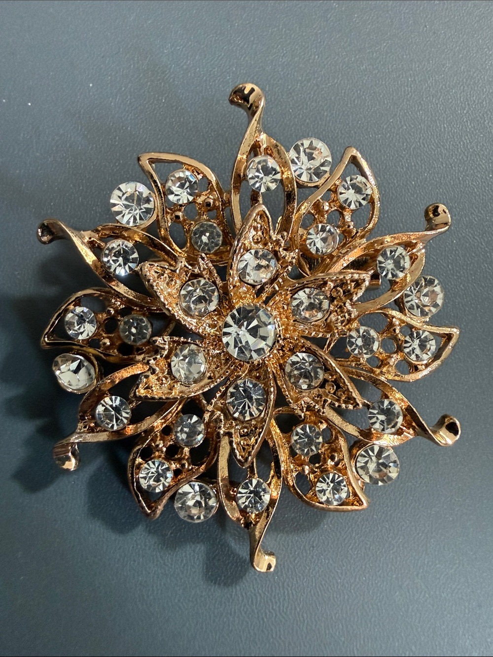 vintage-style brooch adorned with clear rhinestones and a gold-tone finish